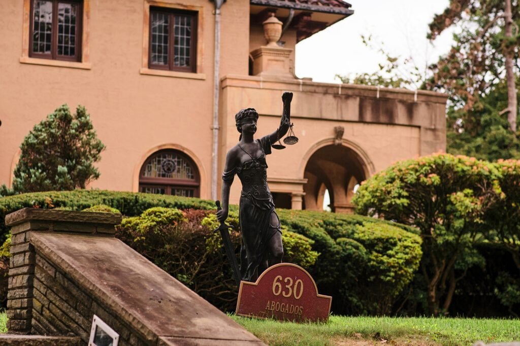 Charming mansion in Arizona City with a Lady Justice statue and manicured garden, perfect for travel and architecture themes.